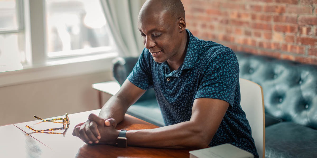 A man praying before reading the Bible.