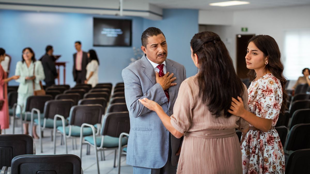 An elder listening empathetically as two sisters approach him at the Kingdom Hall with a concern.