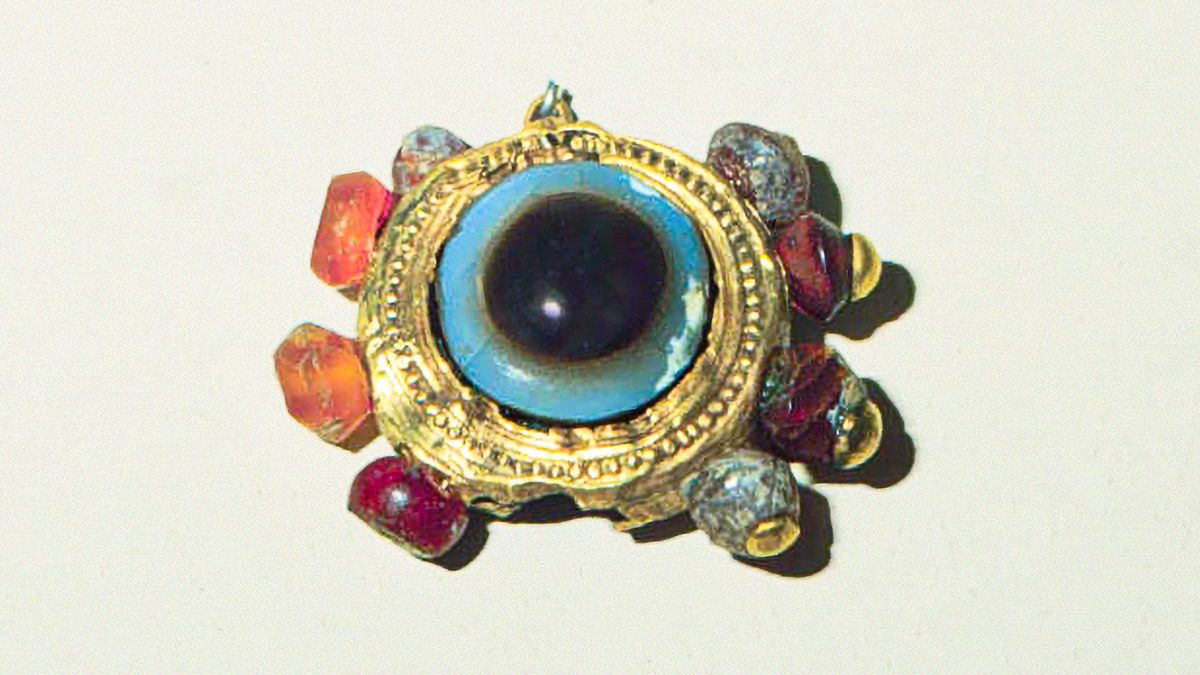 A piece of jewelry made of precious metals and colorful gemstones.